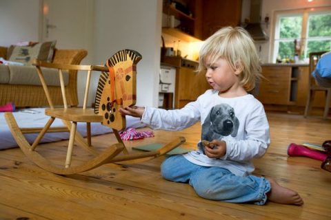 Girl-2-years-playing-with-rocking-horse-Berg-Bavaria-Germany