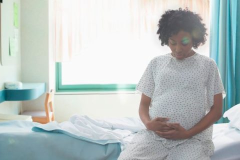 pregnant-african-american-woman-holding-her-stomach-in-hospital