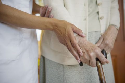 close-up-of-caretaker-helping-older-woman-walk